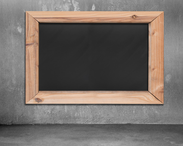 Blank blackboard with wooden frame hanging on concrete wall - Fotó, kép