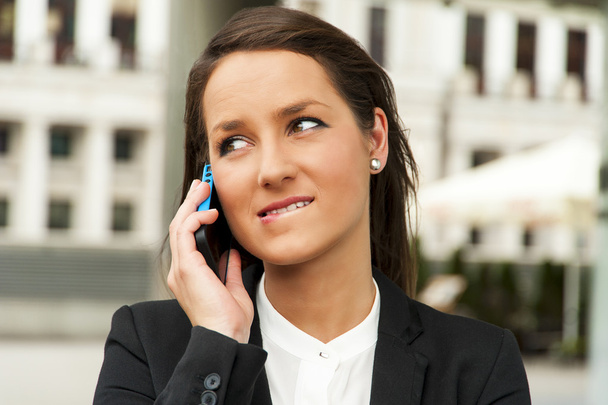 Business woman talking by phone against the glass wall in the ci - Foto, imagen