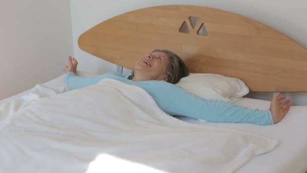 woman in her 50s waking up in the morning and looks happy - Filmati, video