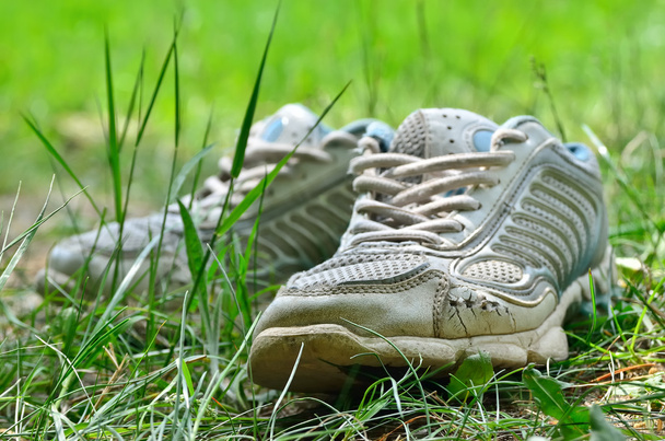Το shabby αθλητικά παπούτσια στο νεαρό γκαζόν - Φωτογραφία, εικόνα