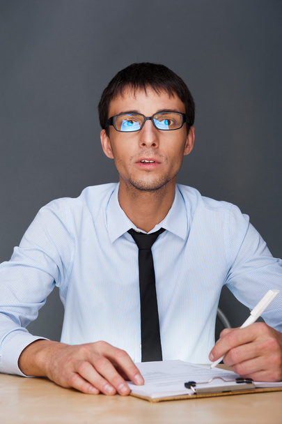 Portrait of an adult business man sitting in the office and sign - 写真・画像