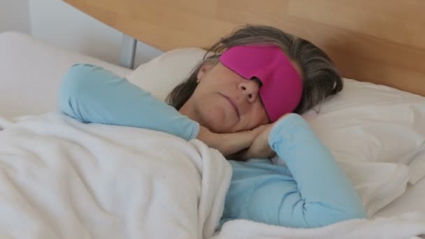 woman in her 50s sleeping with a pink sleeping mask - Imágenes, Vídeo