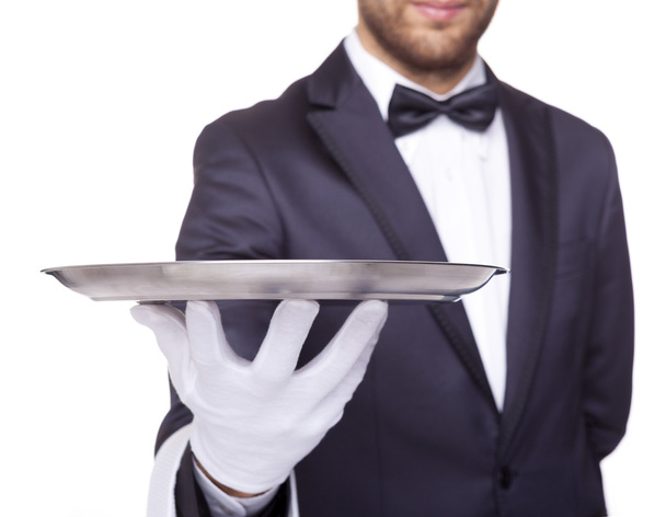 waiter holding an empty silver tray - 写真・画像