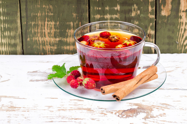 Tea with wild strawberry and cinnamon - Фото, изображение