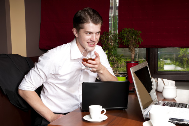 man drinking alcohol when working with a laptop - Foto, Imagen