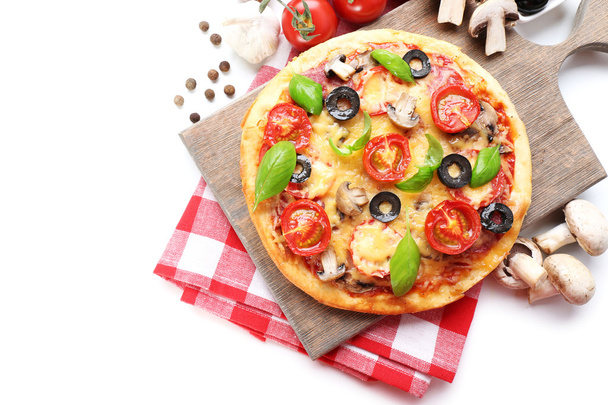 Tasty pizza with vegetables and basil on cutting board isolated on white - Фото, зображення