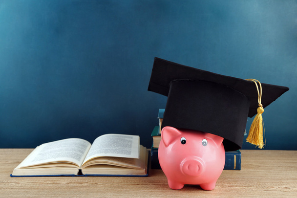 Piggy bank with book and grad hat - Valokuva, kuva