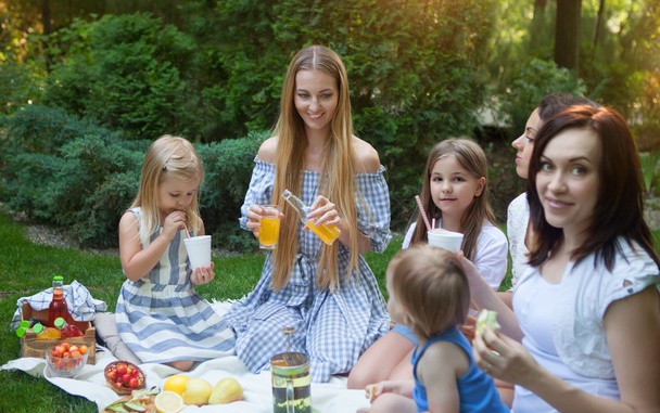 Tres madres e hijas jóvenes felices haciendo un picnic
  - Foto, Imagen