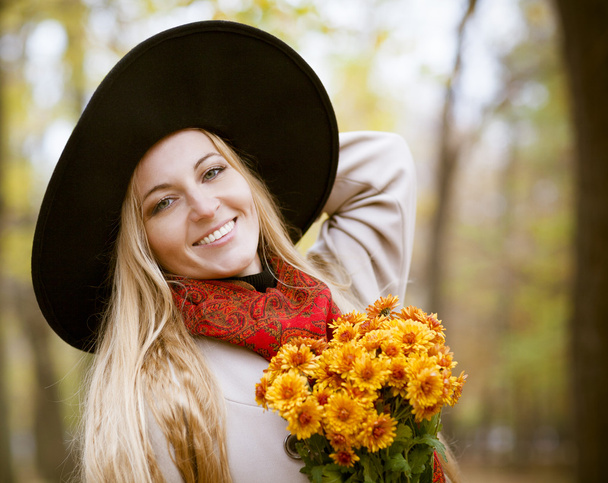 Fashionable blond woman at beautiful autumn alley - Fotoğraf, Görsel
