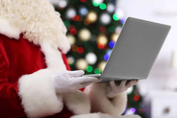 Santa holding laptop  - Фото, изображение