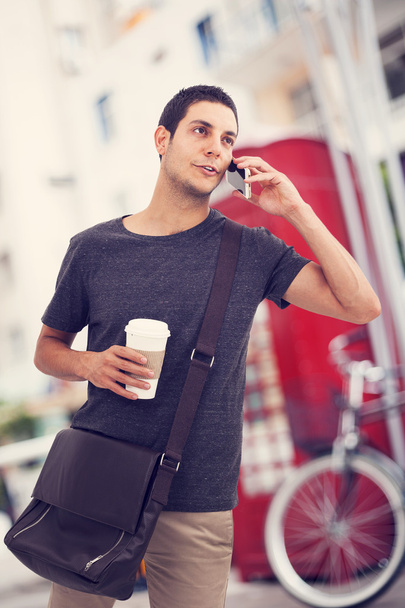 Man talking mobile phone in street - 写真・画像