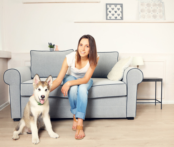 Woman and her malamute dog in room - Fotografie, Obrázek