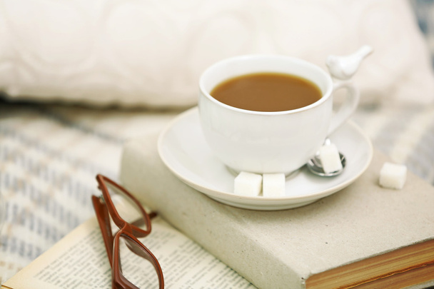 Cup of coffee with books on sofa in living room - Фото, зображення