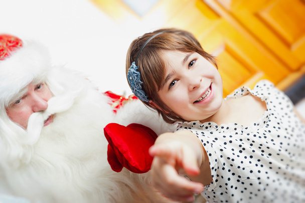 Christmas theme: Santa Claus and little girl having a fun. Indoo - Foto, afbeelding