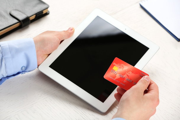 Ember tartja a hitelkártya és a tabletta a munkahelyi háttér - Fotó, kép