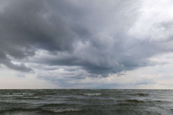 Морские волны на песчаном пляже с бурным небом
 - Фото, изображение