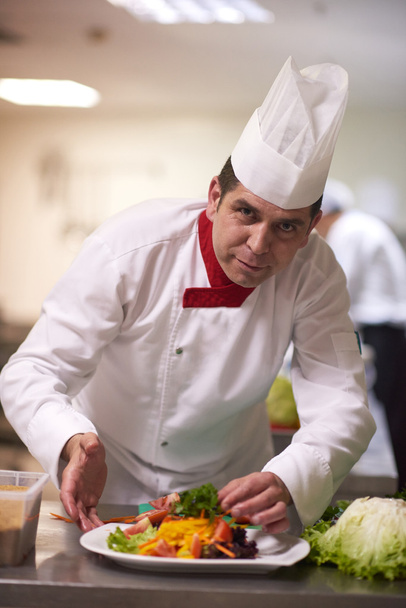 chef en la cocina del hotel preparando y decorando alimentos, deliciosas verduras
 - Foto, Imagen