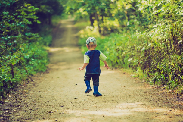 Винтажное фото мальчика, бегущего и играющего в лесу летом
. - Фото, изображение