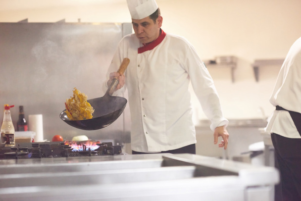 шеф-повар готовит овощи с огнем
 - Фото, изображение