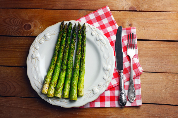 Roasted asparagus on plate on table background - Fotoğraf, Görsel