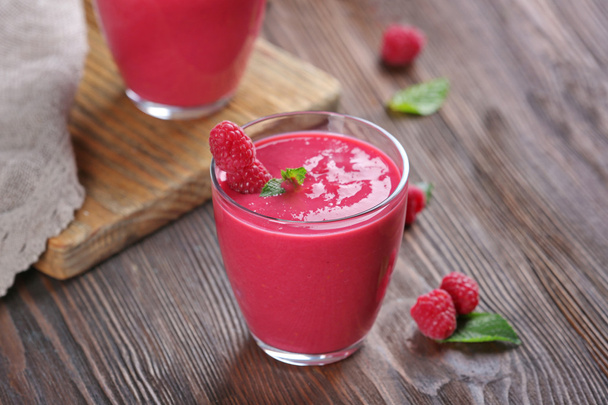 Glasses of raspberry milk shake with berries on wooden table close up - Valokuva, kuva