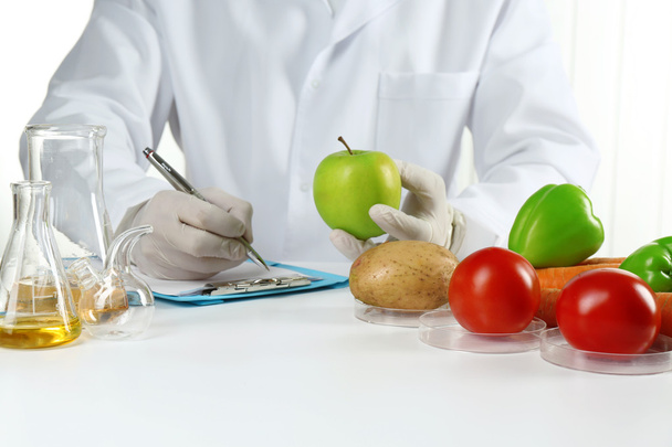 Επιστήμονας εξετάζει λαχανικά στο εργαστήριο - Φωτογραφία, εικόνα