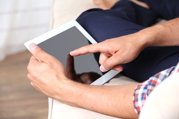 Male hand holding PC tablet on home interior background - Photo, Image