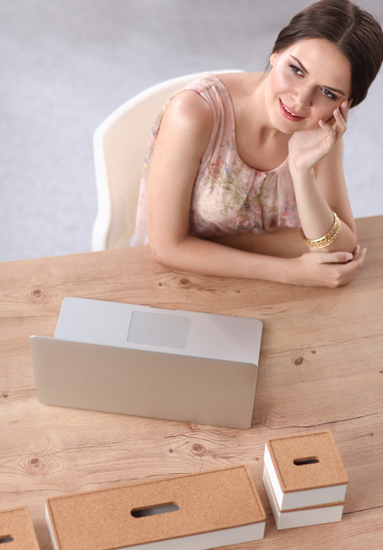 Привлекательная деловая женщина, сидящая на столе в офисе - Фото, изображение