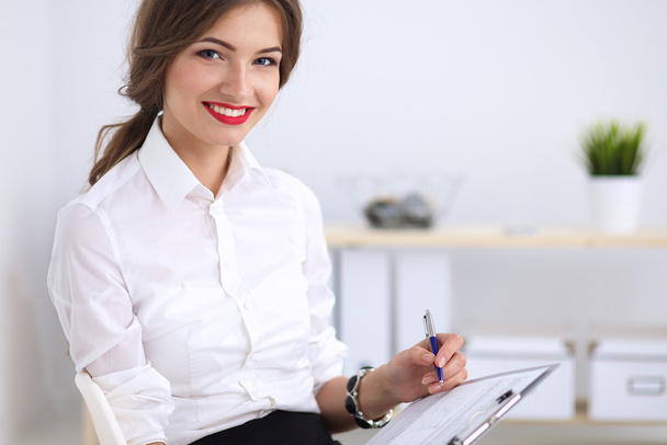 Attractive businesswoman sitting  in the office - Photo, image