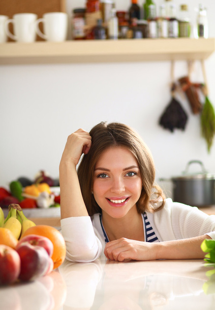 Young woman standing near desk in the kitchen - Foto, Imagem
