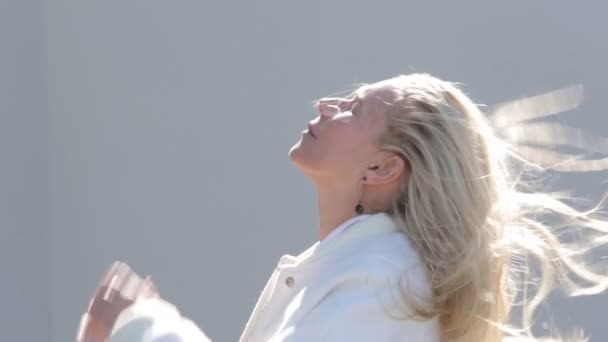 blonde Frau spielt mit ihren Haaren im Freien - Filmmaterial, Video