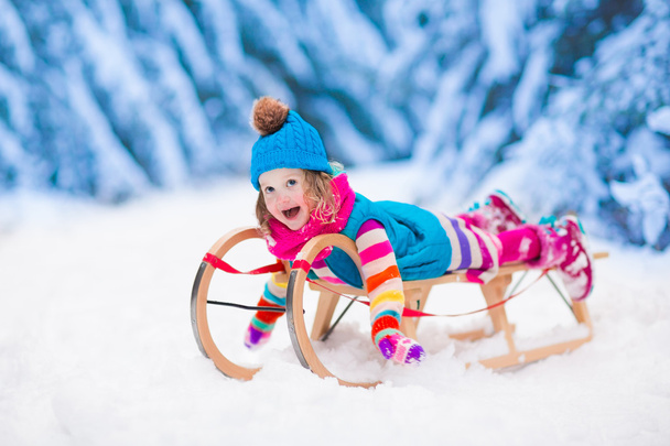 Little girl playing in snowy winter forest - Photo, Image