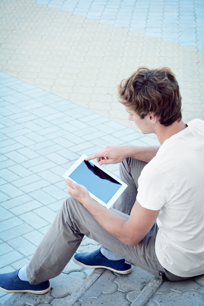 Young man is using a tablet - 写真・画像