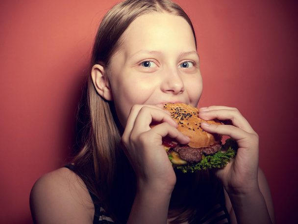 Teen girl eating a burger - Foto, Bild