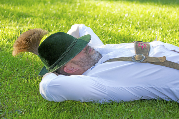 bavarian man sleeping on the grass - Valokuva, kuva