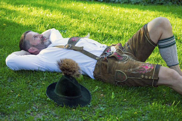 bavarian man lying on the grass - Foto, Imagen