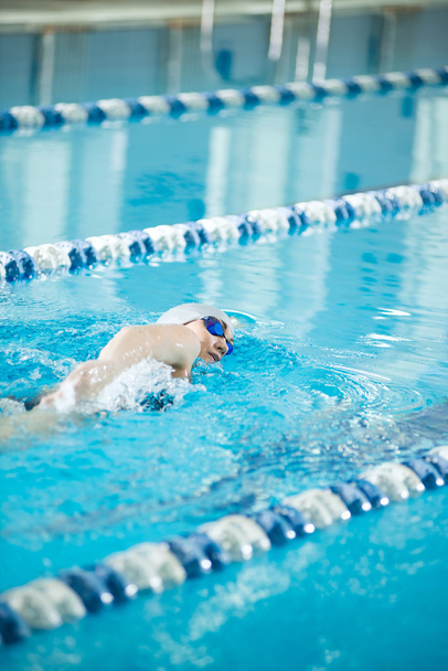 Young girl in goggles swimming front crawl stroke style - Foto, imagen