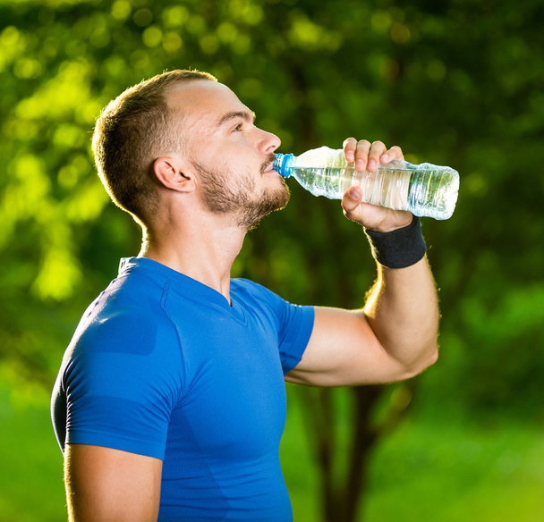 Athletic mature man drinking water from a bottle - Fotoğraf, Görsel