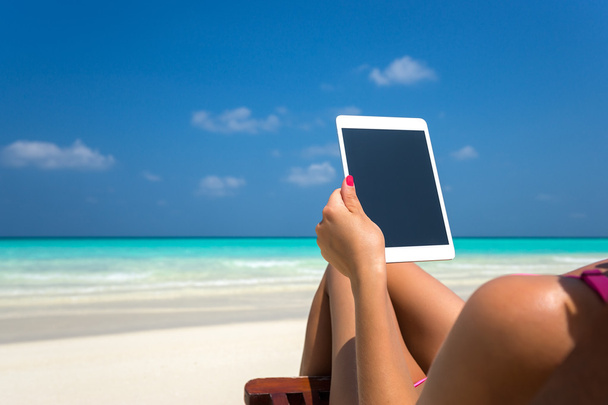 Tableta vacía en blanco en manos de mujeres en la playa
 - Foto, imagen