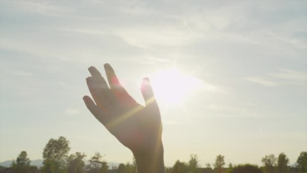 Αργή κίνηση από κοντά: Χέρι κουνώντας πέρα από τον ήλιο - Πλάνα, βίντεο