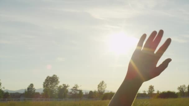 Zwolnionym tempie: Słońce świeci przez palce dłoni macha - Materiał filmowy, wideo