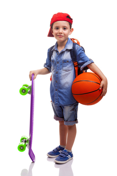school boy holding a skateboard and a basketball - Foto, Bild