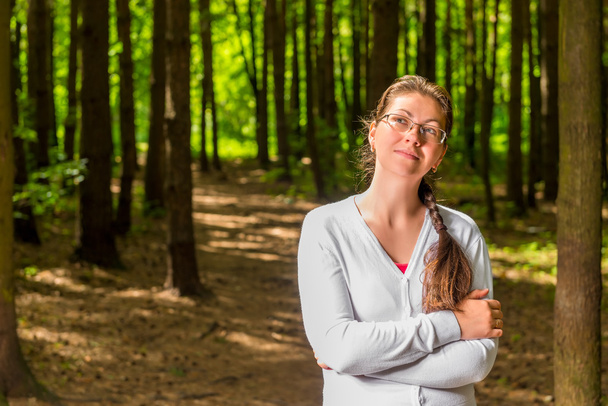 Портрет молодої вдумливої жінки в окулярах у лісі
 - Фото, зображення