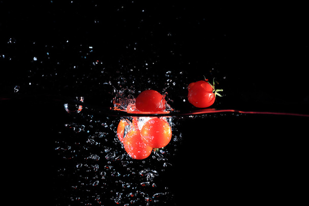 Splashing tomatoes into a water - Foto, imagen