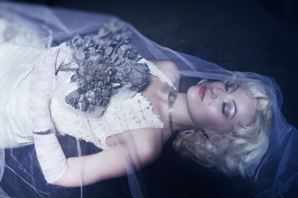 Sleeping Beauty. Beautiful lifeless bride in white dress lying o - Photo, image