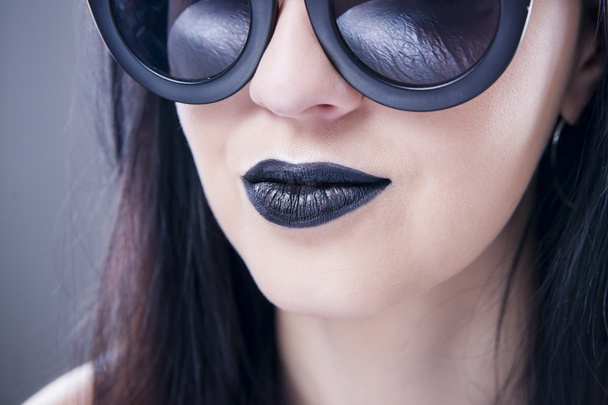 Beautiful woman fashion model portrait in sunglasses with black lips and earrings. Creative hairstyle and make up - Foto, imagen