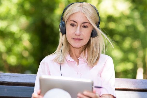 Mature woman listening music - Foto, Imagen