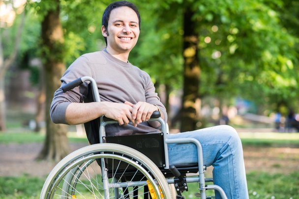 Glimlachende man op een rolstoel - Foto, afbeelding