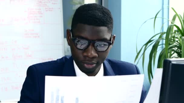 African American in the office stylish suit reads an important documentation - Séquence, vidéo