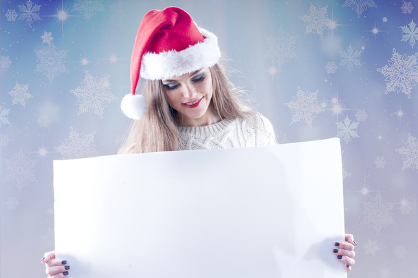 Happy young christmas girl holding a blank paper sign - Foto, immagini